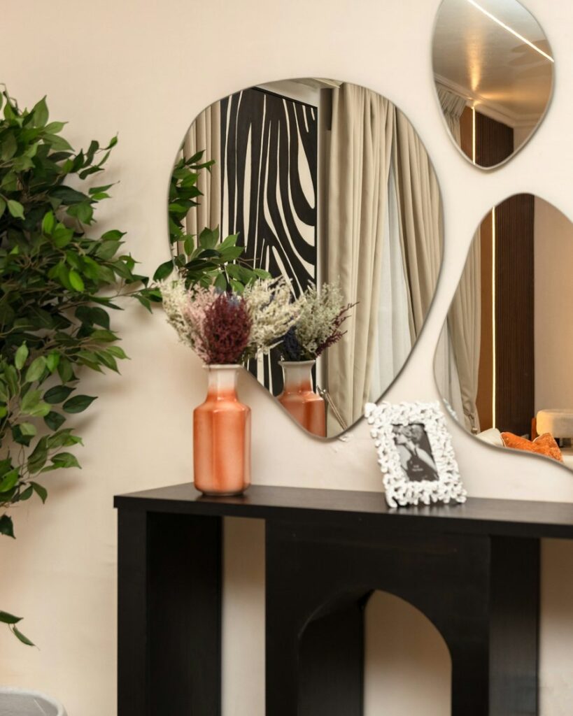 Entryway console with round mirrors and a potted tree