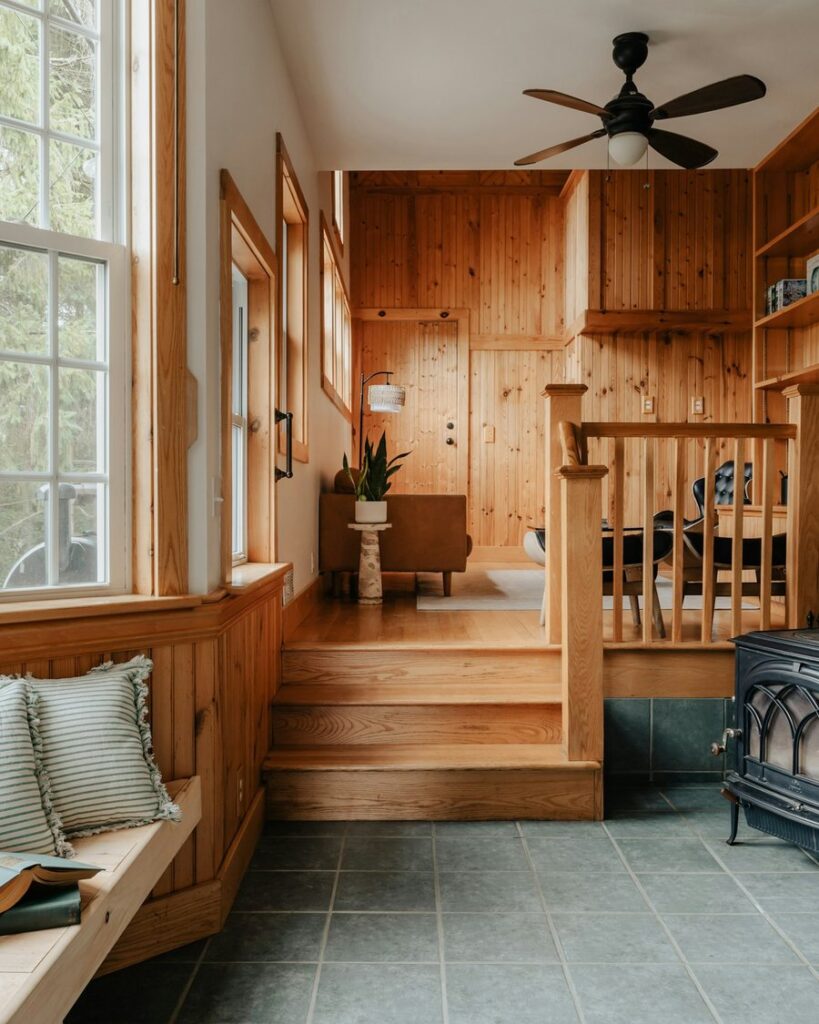 Window seat reading nook with cushions in a wooden room
